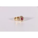 Cluster ring with an oval ruby and ten diamond brilliants, diamond set shoulders in 18ct gold.