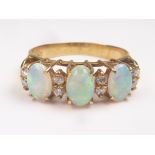 Ring with three opals and four pairs of tiny diamond brilliants in gold, '750'. Size 'P'.