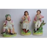Pair of 19th century Staffordshire pottery figures of a boy holding a bird's nest and his