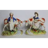 Pair of 19th century Staffordshire figures of cows with farmer and his companion, each standing on a