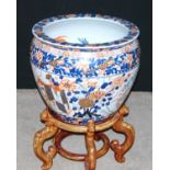 Large Japanese Imari style fish bowl decorated with chrysanthemums and traditional scenes, on stand,