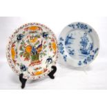 Two late 18th century Delft plates, one in blue and white oriental pattern, the other in colours