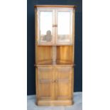 Ercol corner cupboard, the projected moulded cornice over glazed doors, open shelf, panelled doors