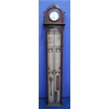 Admiral Fitzroy barometer mounted by a clock with white face, Roman numerals, over glazed trunk