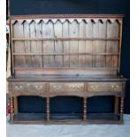 19th century oak dresser with projected moulded cornice over arched apron, open shelves, moulded