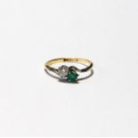 Cross-over ring with diamond brilliant and rectangular emerald, '18ct Plat', size N.