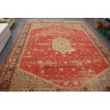 Large Persian carpet with central medallion over pink ground with assorted motifs, spandrels and