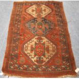 Kazak rug with triple medallions over red ground and star border, 202cm x 132cm.