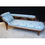 Victorian oak chaise longue scrolling from left to right with cushioned back over carved brackets,