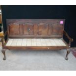 18th century oak settle with crossbanded panelled back over open arms, raised on cabriole legs