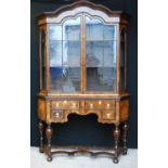 Dutch walnut display cabinet on stand, the arched moulded cornice over glazed doors and canted