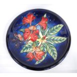Moorcroft Simeon pattern charger with floral decoration over blue ground, marks to the base, 1999,