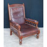 Late Victorian mahogany and faux leather gent's armchair with arched top rail flanked by turned