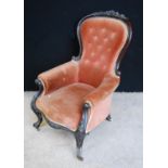 Victorian button-back armchair with floral carved frame, cushioned arms and seat, raised on cabriole