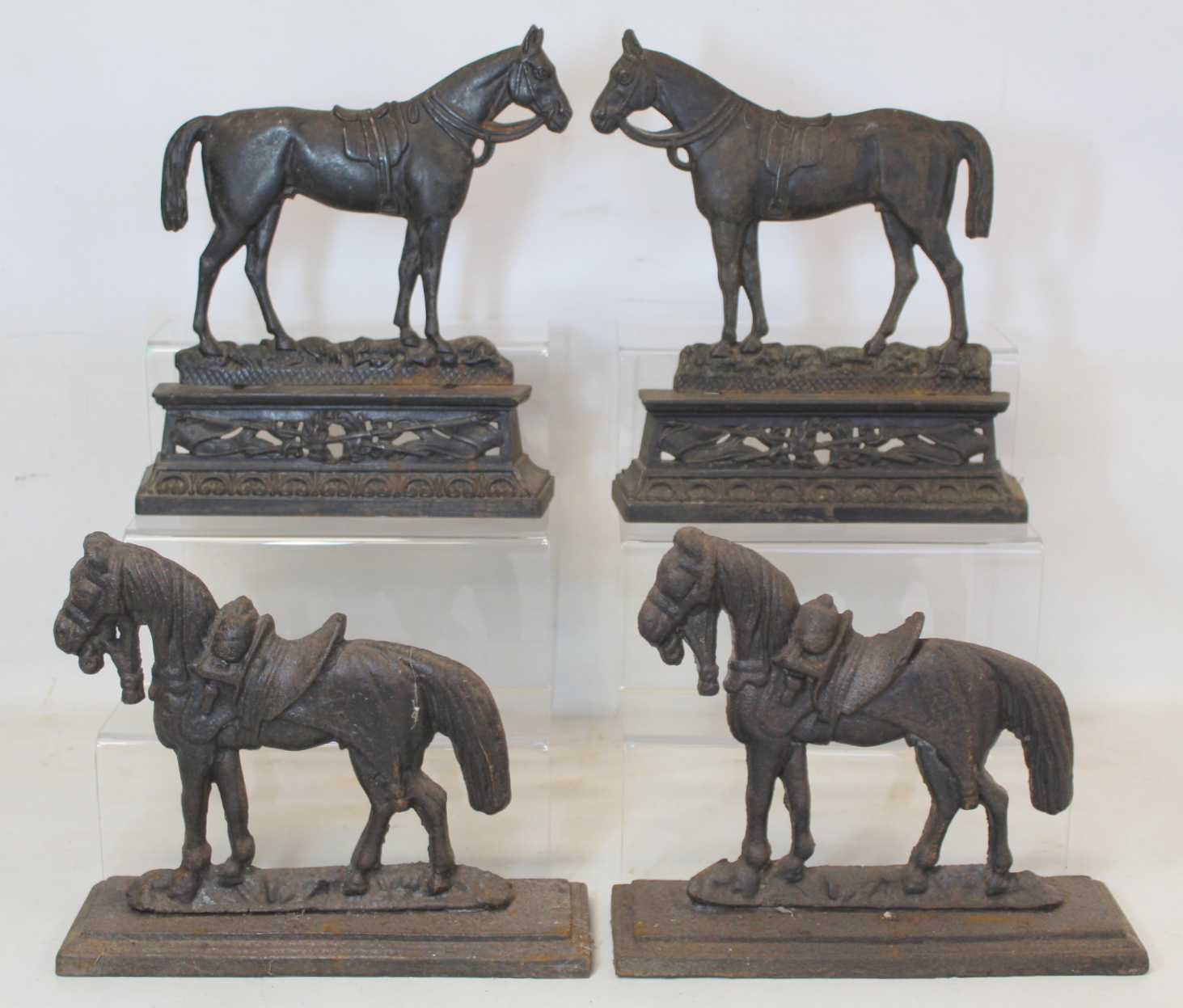 Two pairs of late 19th/early 20th century cast metal doorstops or half ornaments in the form of