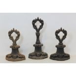 Pair of Victorian cast iron doorstops of foliate scroll form with pierced handles, each 23cm high