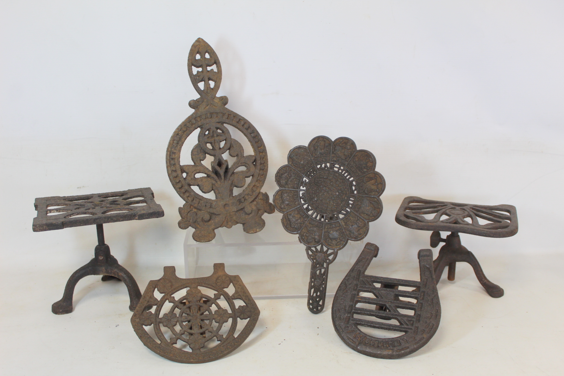 Four Victorian cast iron grate trivets incl. one of horseshoe form inscribed "Good Luck" and one