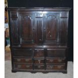 Oak hall cupboard, the projected moulded cornice over panelled doors, fluted columns, stepped