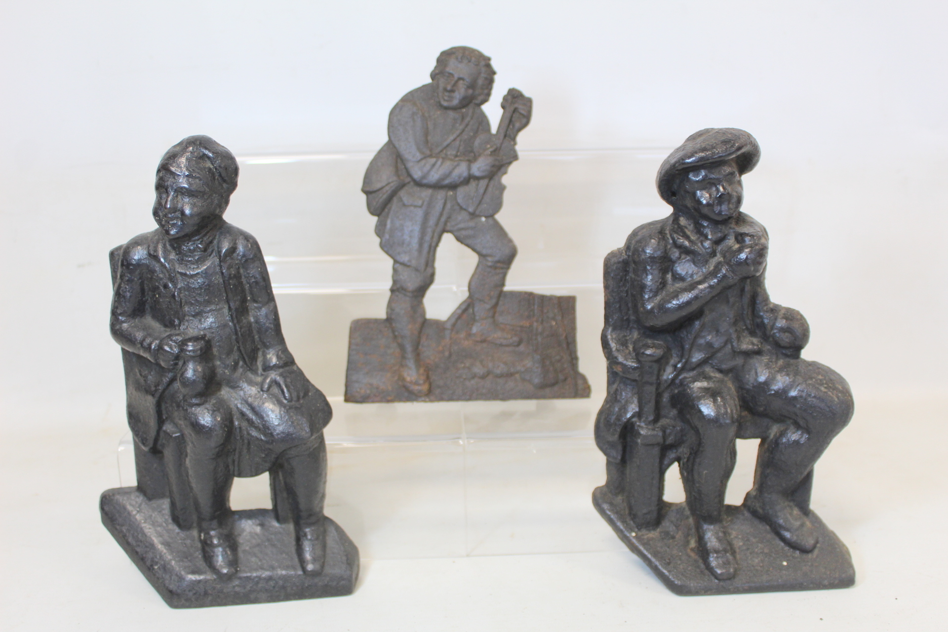 Pair of Victorian black painted cast iron doorstops or half ornaments depicting two seated men