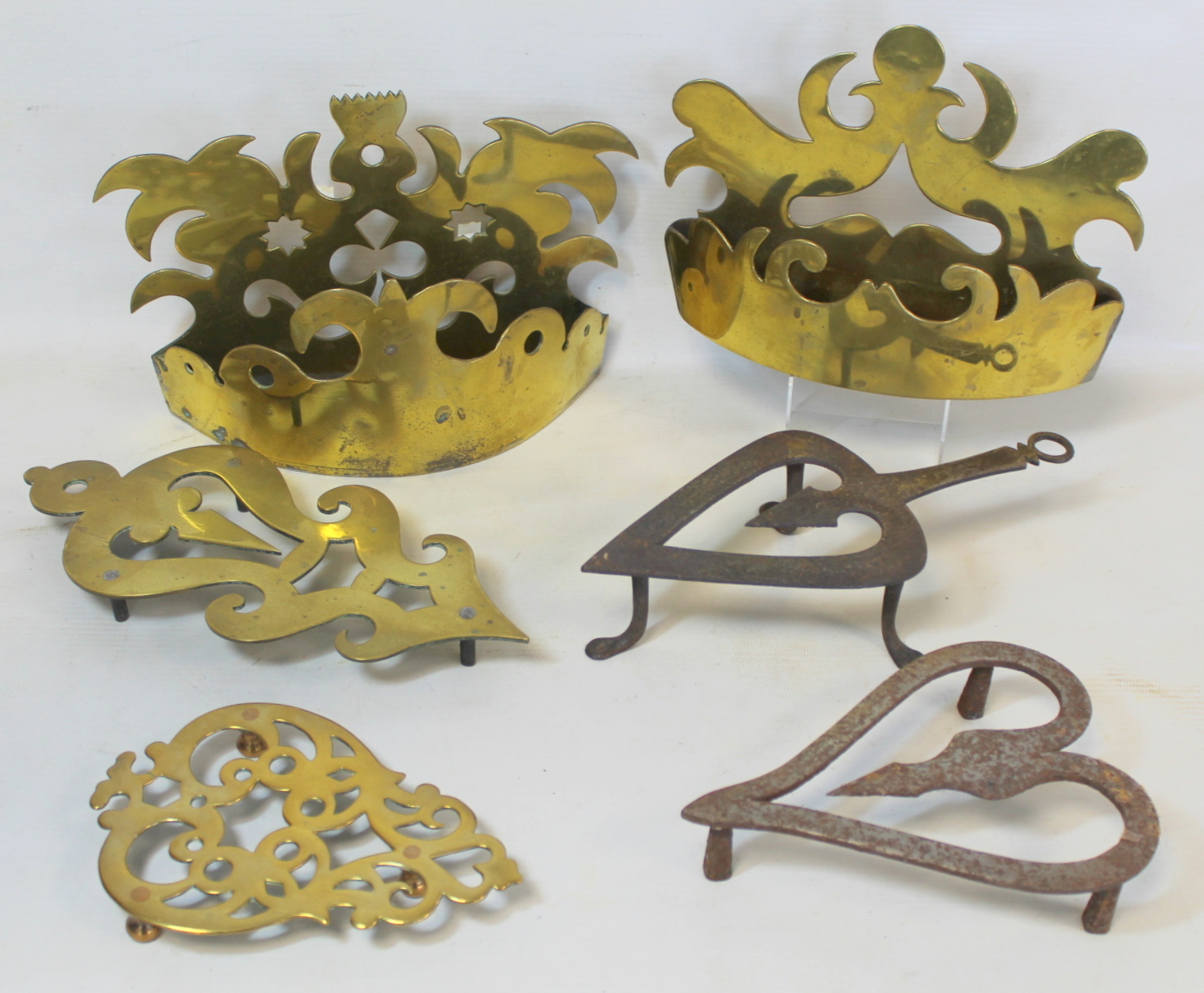Two Victorian brass half ornaments with pierced scrolled decoration; two brass trivets of pierced