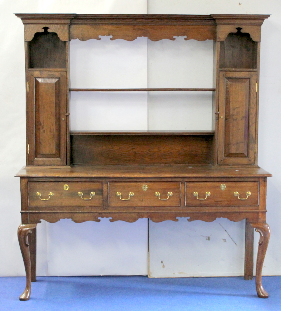 18th century oak dresser,the open rail back flanked by two spice cupboards over three frieze