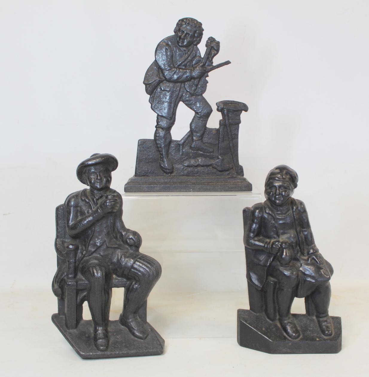 Pair of Victorian black painted cast iron doorstops or half ornaments depicting two seated men