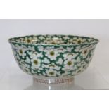 Chinese bowl with lobed rim decorated with prunus flowers on green lattice ground. Painted red