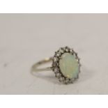 Diamond and opal oval cluster ring with sixteen brilliants in 18ct white gold, 1975. Size 'R 1/2'.