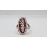 Platinum and diamond ring set with five vertical diamonds, surrounded by caliber cut rubies and a