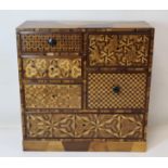 Late 19th Century/early 20th Century Japanese parquetry table top chest of six drawers. 31cm wide.