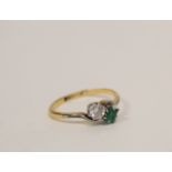 Cross-over ring with diamond brilliant and rectangular emerald, '18ct Plat'. Size 'N'.
