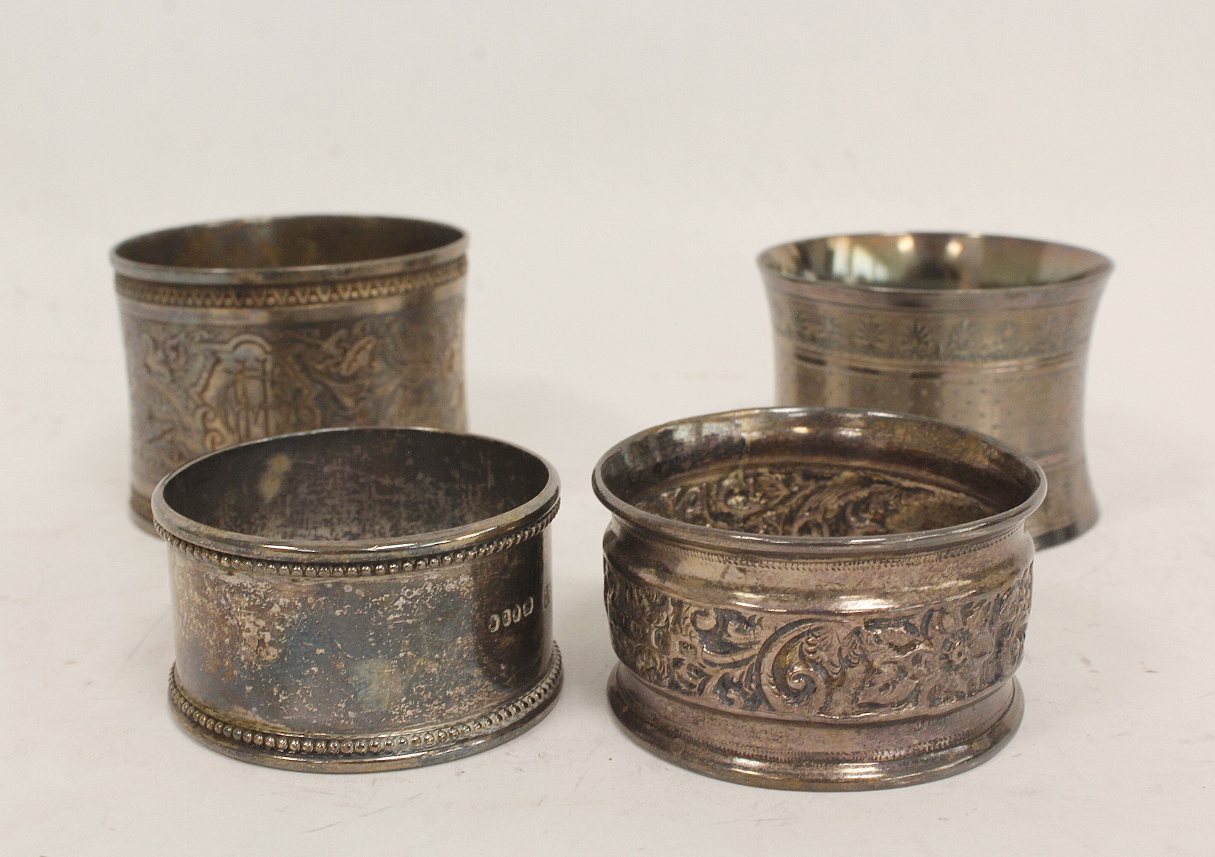 Two French silver napkin rings with engraved leafage inscribed and dated 1877 and another two