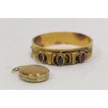 Victorian gold hinged bangle with three garnets (20g gross) and a metal locket. (2).