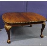 Edwardian mahogany extending table, the oval top with scroll edge raised on carved cabriole supports