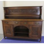 Attributed to Arthur Simpson of Kendal, an oak sideboard, the carved back with shelf and barley