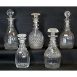 Four 19th century triple ring neck decanters with cut decoration; also another with moulded