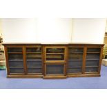 Oak breakfront dwarf bookcase with carved moulding, the shelves enclosed by six glazed doors on