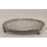 Silver circular tray with profuse embossed scroll and flowers upon matting, with similar separate
