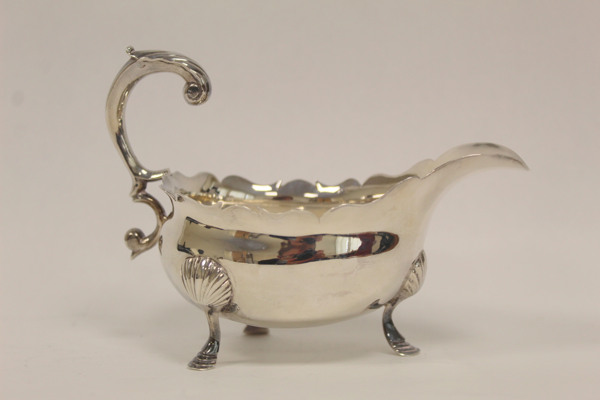 Silver sauce boat with flying scroll handle and waved edge on pad feet, by Robert Cox 1752, 5 1/2