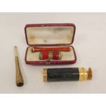 Gilt metal scent spray modelled as a telescope, a lady's evening cigarette holder and another,