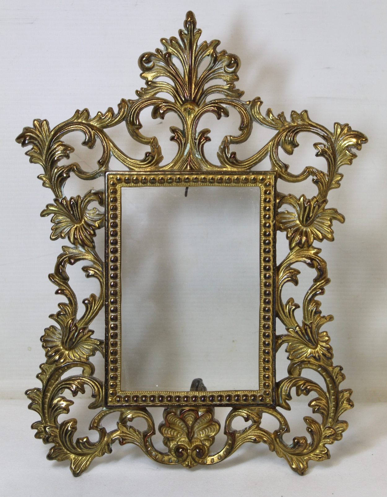 Antique gilt copper pierced foliated scroll photograph frame with folding scroll stand to fit