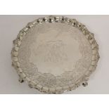 Silver circular tray with shaped moulded and scallop border, embossed with scrolls, flowers and