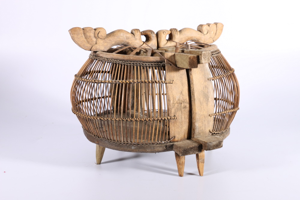 A double basketwork and carved wood bird cage, possibly Middle Eastern, with carved bird handles,