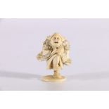 Late 19th or early 20th Century carved ivory netsuke depicting a man dancing and banging a drum,
