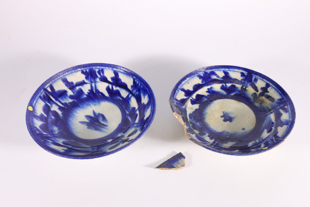 Two 18th or 19th century Iranian blue and white shallow bowls, with deep foot well and sylised