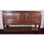 19th century carved oak dresser base or court cupboard with carved frieze, panel doors and skirt