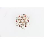 Large unhallmarked gold opal and ruby snowflake shaped combination brooch pendant, 4cm diameter