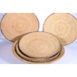 Six African woven coiled flat dishes, 61cm, down to 46cm