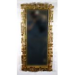 An American brutalist style gilt wall mirror in the manner of Syroco, 106cm x 50cm