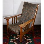 Arts & Crafts movement oak framed lounger armchair upholstered in floral patterned fabric bearing